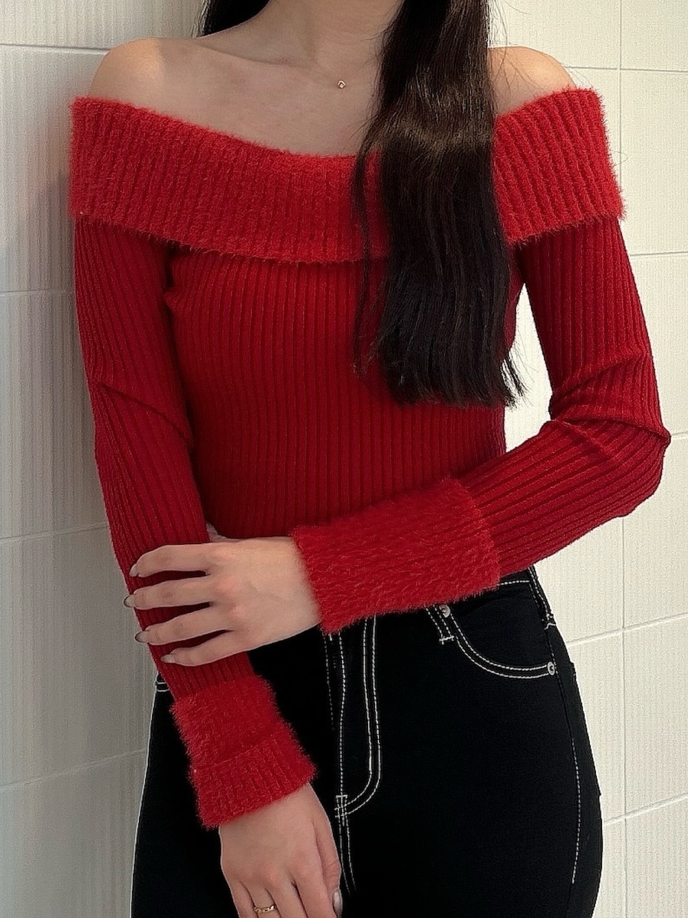 レッド系のニット/セーター、ブルー系のデニムパンツ、ブラック系のブーツを着用したレディースの冬コーディネートの7枚目の写真