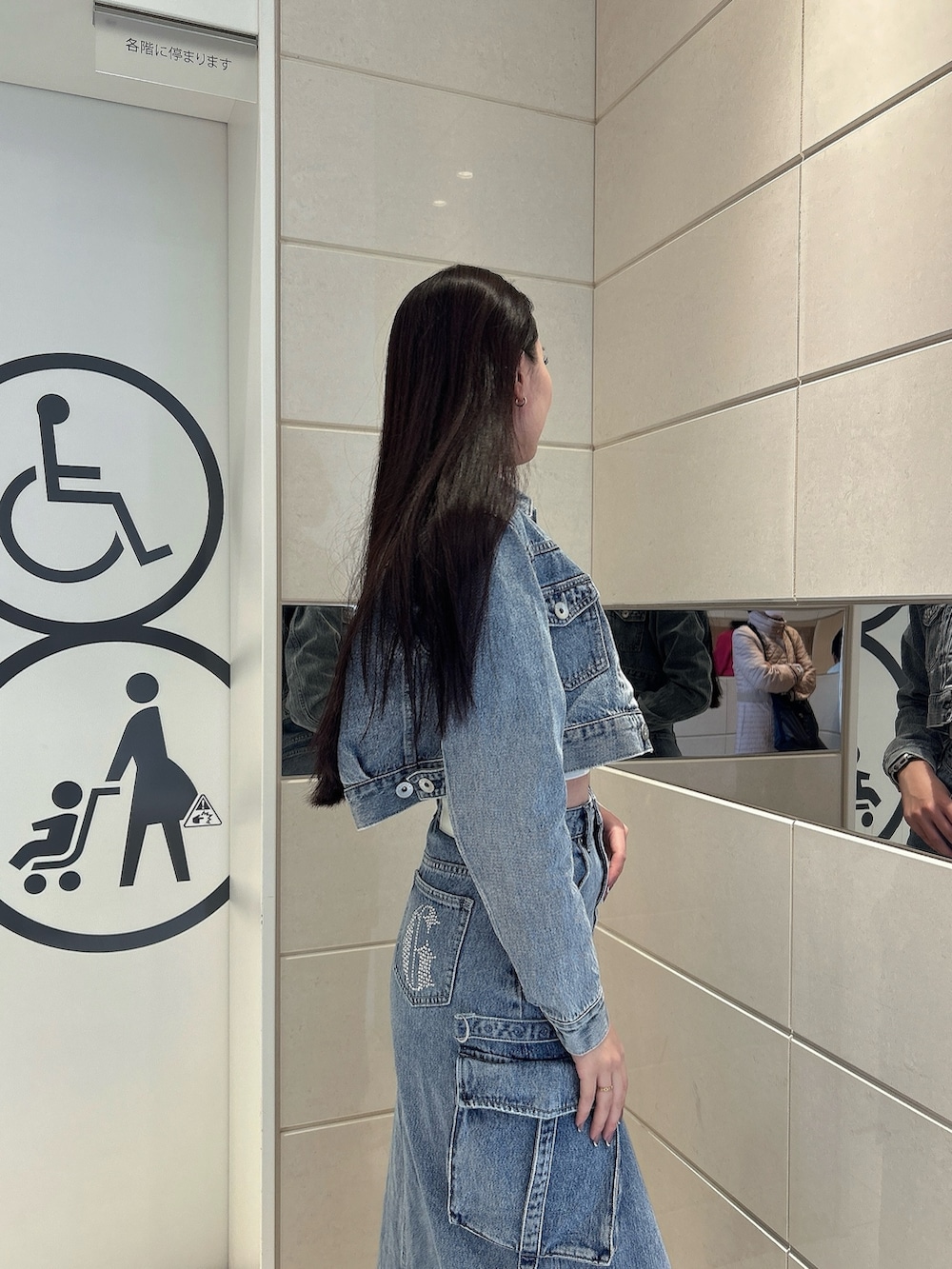 ホワイト系のスニーカー、ブルー系のデニムスカート、ブルー系のデニムジャケットを着用したレディースの冬コーディネートの5枚目の写真