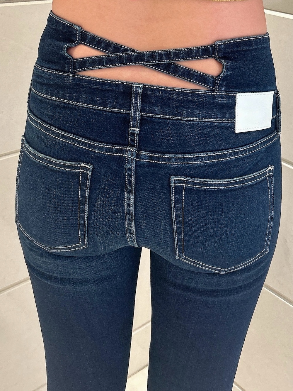 イエロー系のニット/セーター、ブルー系のデニムパンツ、ブラック系のパンプスを着用したレディースの夏コーディネートの7枚目の写真