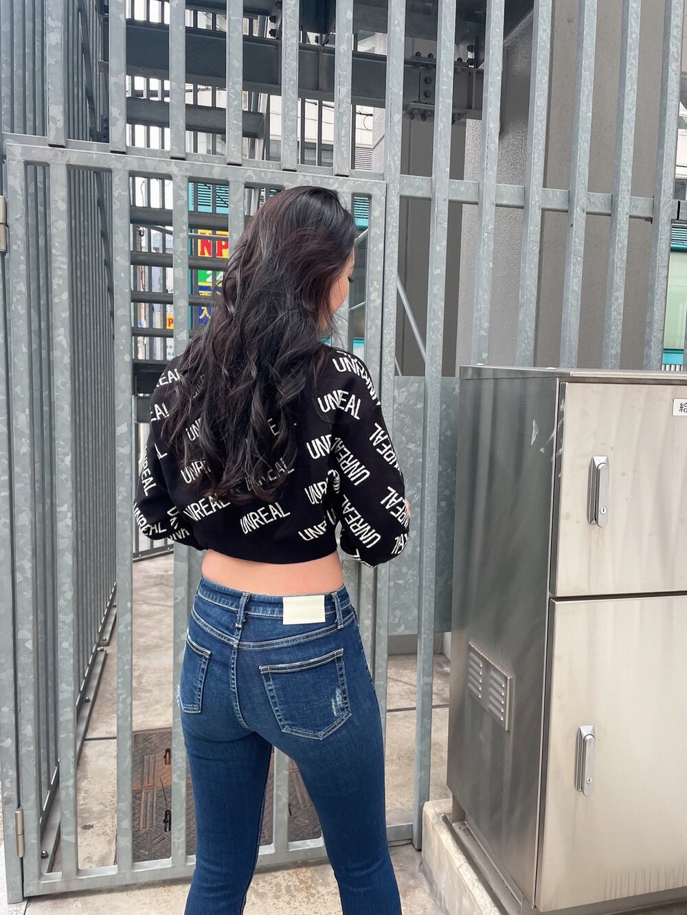 ブラック系のニット/セーター、ブルー系のデニムパンツ、ブラック系のパンプスを着用したレディースの冬コーディネートの5枚目の写真