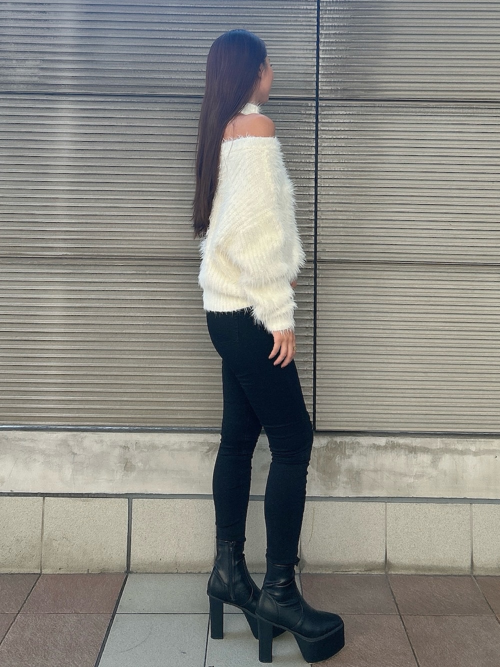 ホワイト系のニット/セーター、ブラック系のデニムパンツ、ブラック系のブーツを着用したレディースの秋コーディネートの2枚目の写真