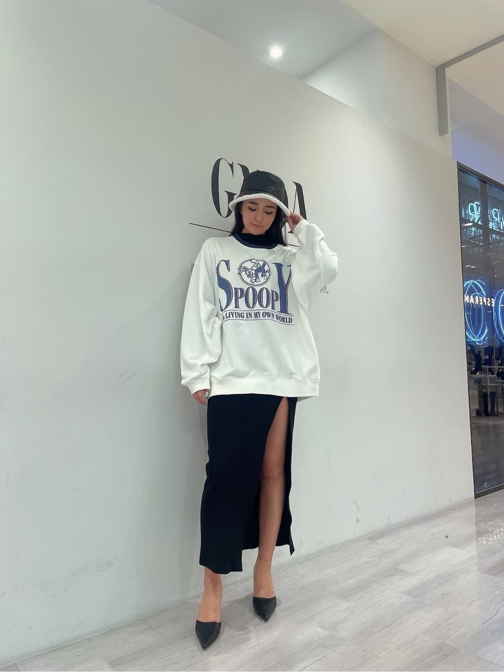 ホワイト系のスウェット、ブラック系のパンプス、ブラック系のワンピースを着用したレディースの秋コーディネートの5枚目の写真