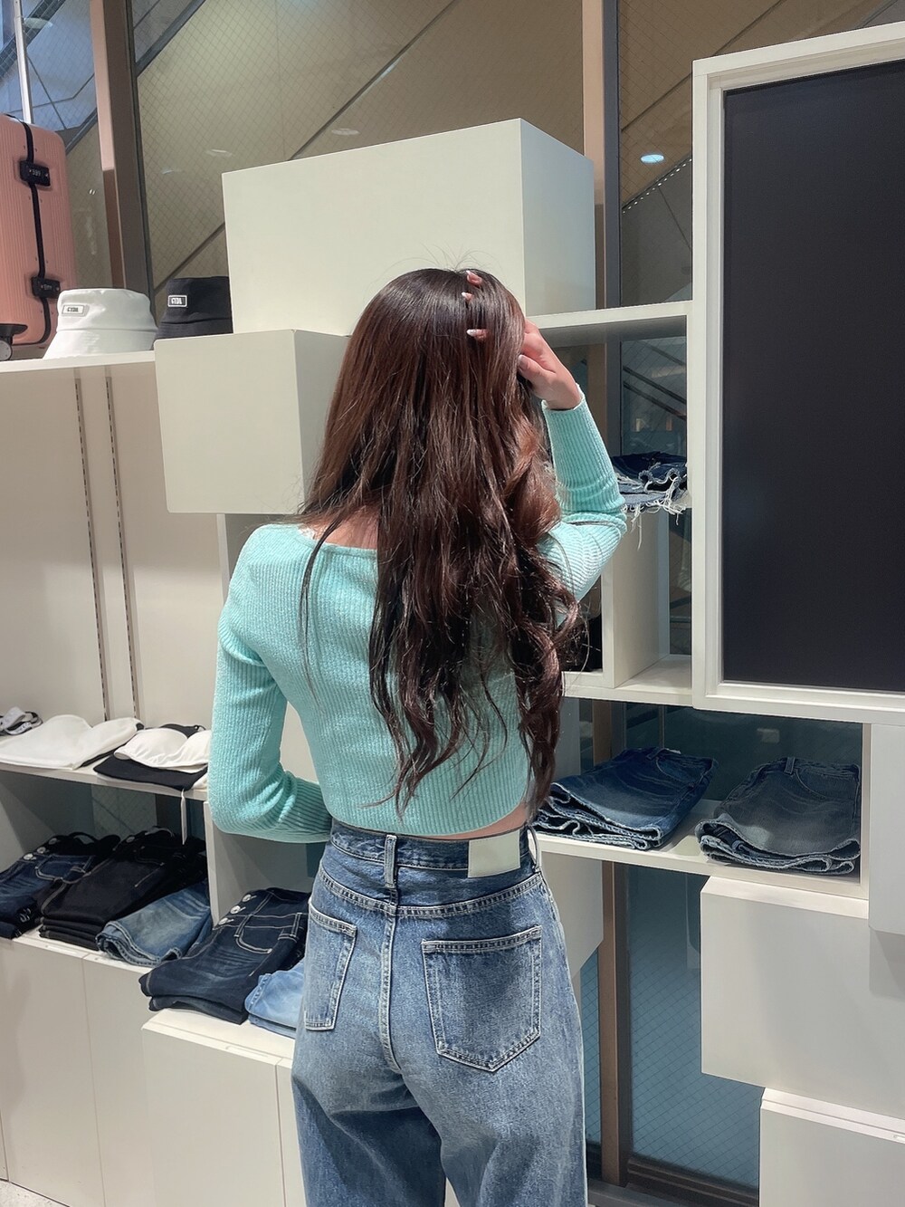 グリーン系のカーディガン/ボレロ、ブルー系のデニムパンツ、ブラック系のパンプスを着用したレディースの冬コーディネートの5枚目の写真