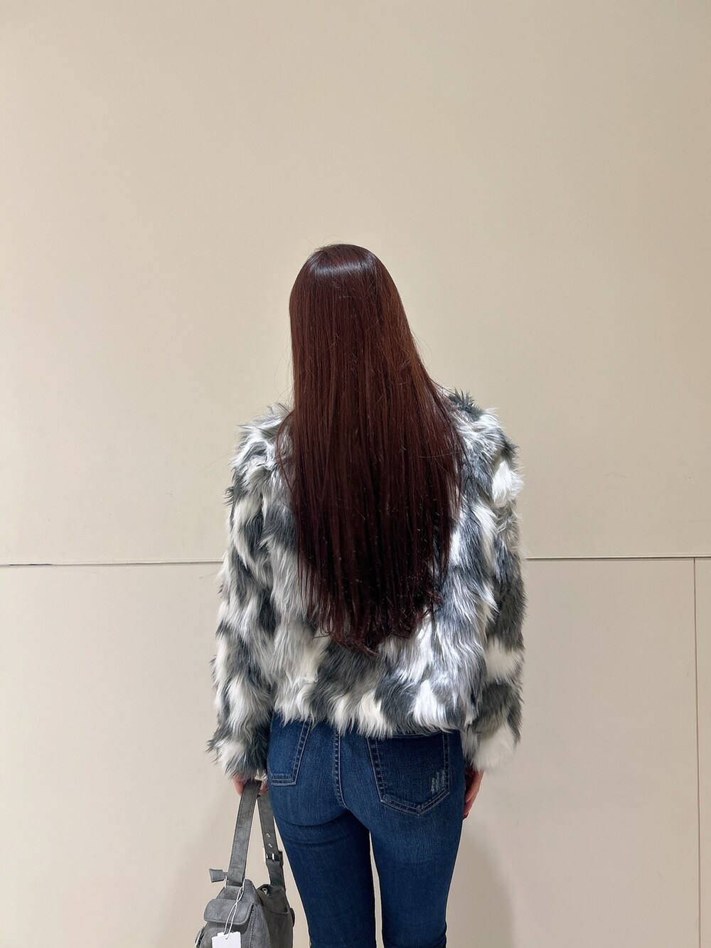 ブルー系のデニムパンツ、ブラック系のブーツ、グリーン系のショルダーバッグを着用したレディースの秋コーディネートの6枚目の写真
