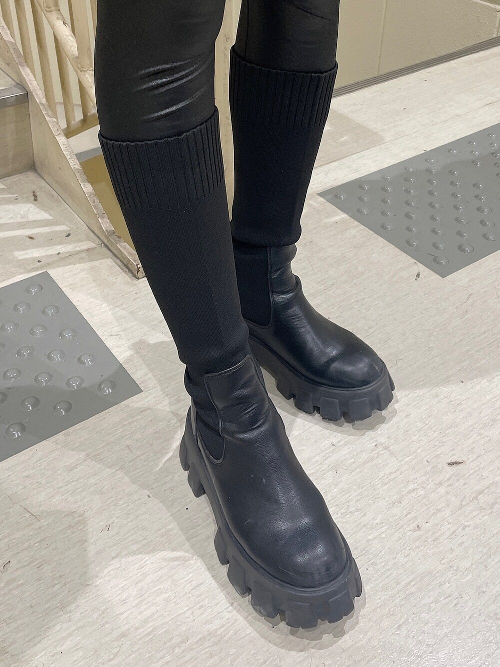 イエロー系のスウェット、ブラック系のブーツ、ブラック系のレギンス/スパッツを着用したレディースの秋コーディネートの7枚目の写真