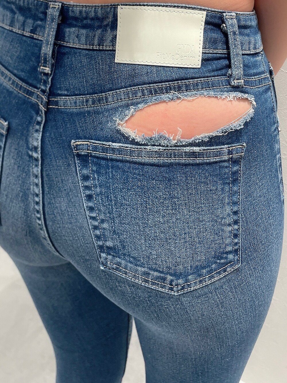 ブルー系のデニムパンツ、ホワイト系のTシャツ/カットソー、ベージュ系のトレンチコートを着用したレディースの春コーディネートの8枚目の写真