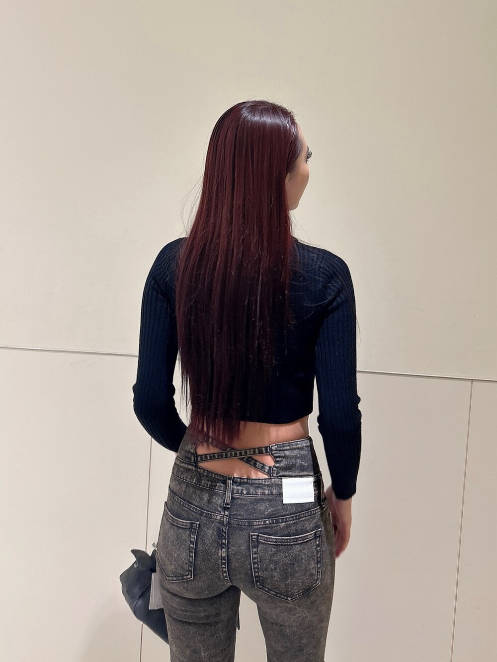 ブラック系のニット/セーター、ブルー系のデニムパンツ、グレー系のショルダーバッグを着用したレディースの秋コーディネートの6枚目の写真