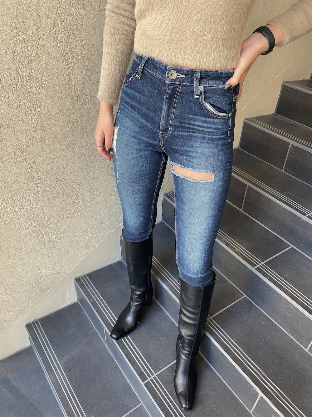 ベージュ系のニット/セーター、ブルー系のデニムパンツ、ブラック系のブーツを着用したレディースの秋コーディネートの5枚目の写真