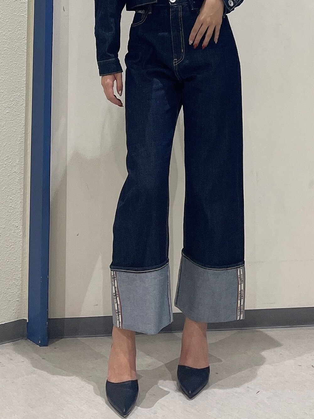 ブルー系のデニムパンツ、ブルー系のデニムジャケット、ブラック系のパンプスを着用したレディースの秋コーディネートの7枚目の写真