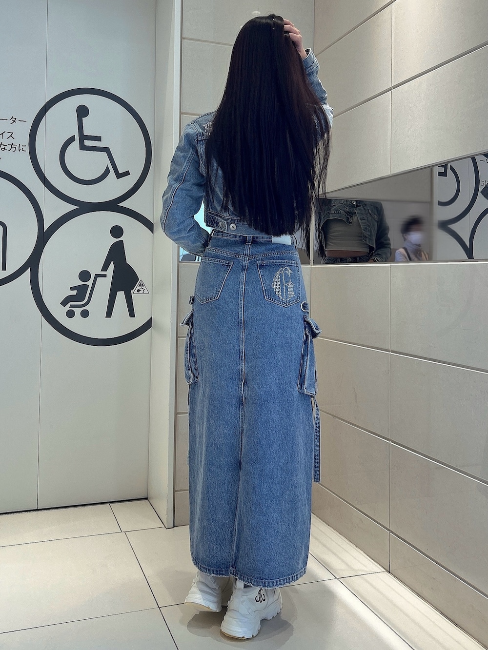 ホワイト系のスニーカー、ブルー系のデニムスカート、ブルー系のデニムジャケットを着用したレディースの冬コーディネートの3枚目の写真