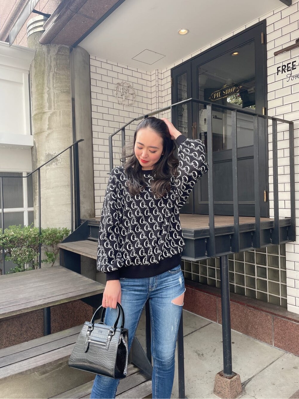 ブラック系のニット/セーター、ブラック系のパンプス、ブルー系のデニムパンツを着用したレディースの冬コーディネートの2枚目の写真