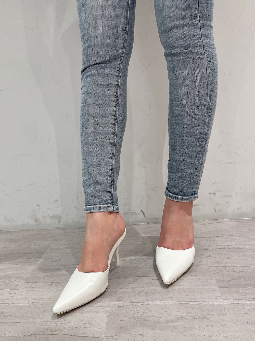 グリーン系のニット/セーター、ブルー系のデニムパンツ、ホワイト系のパンプスを着用したレディースの春コーディネートの7枚目の写真