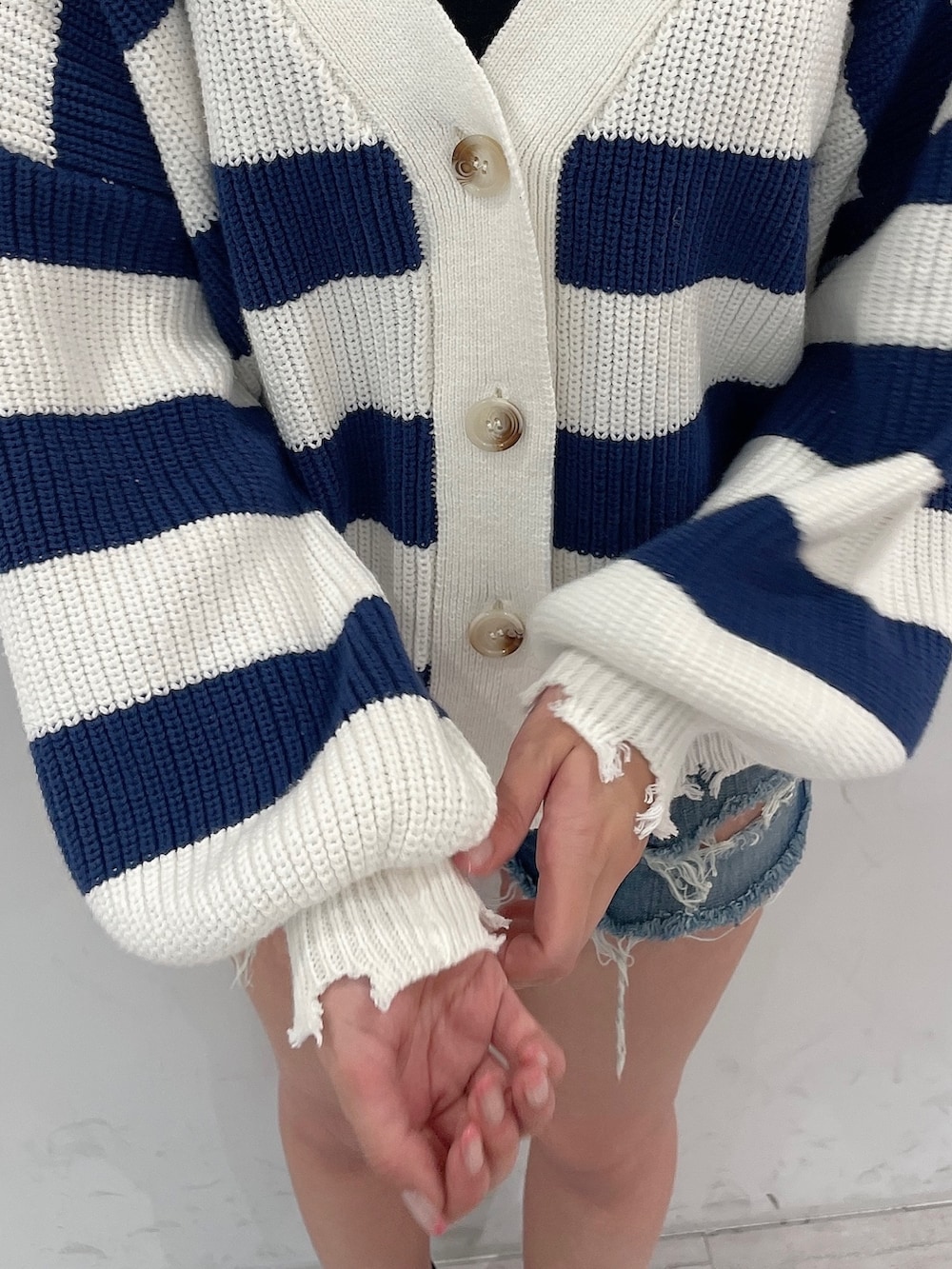 ブルー系のデニムパンツ、ブルー系のカーディガン/ボレロ、ブラック系のキャミソールを着用したレディースの春コーディネートの7枚目の写真