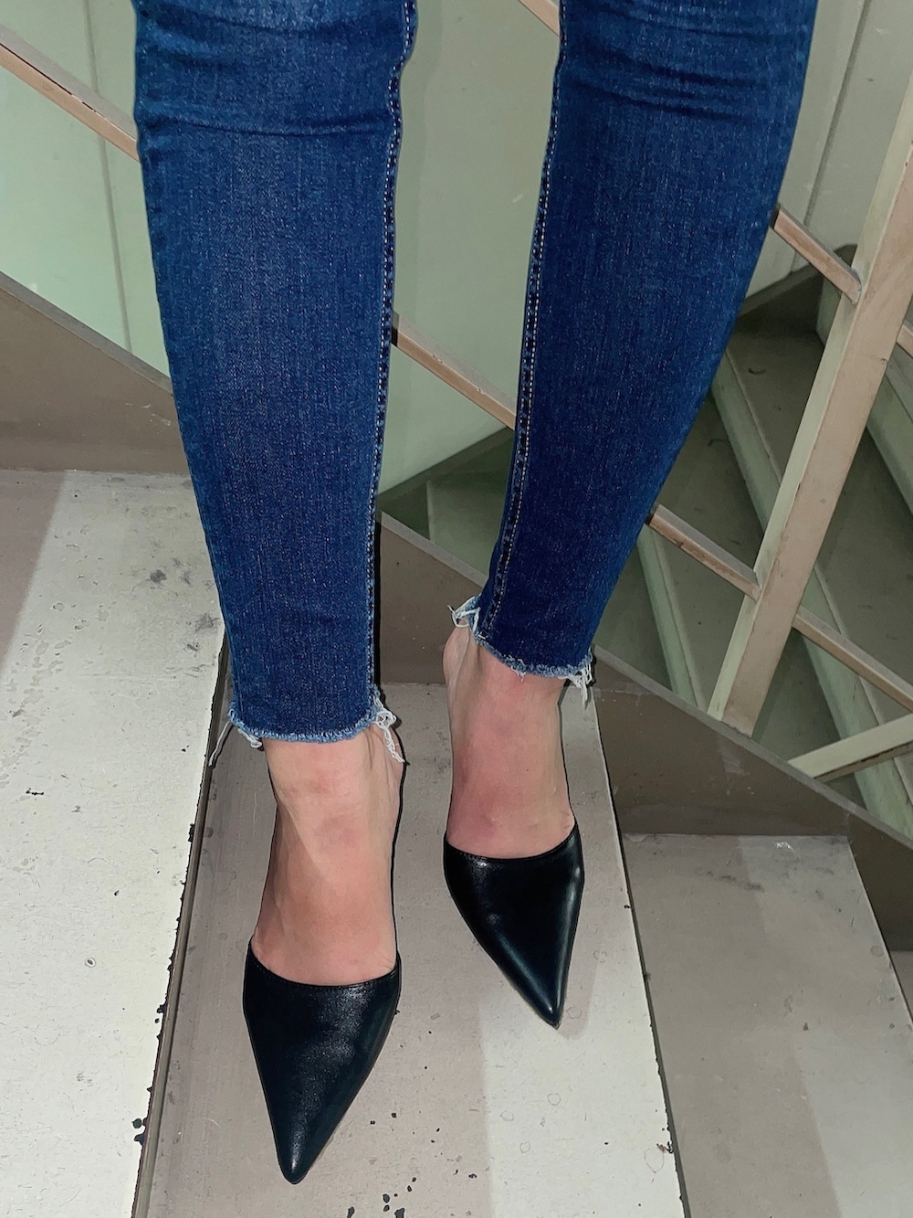 ブルー系のデニムパンツ、ブラック系のニット/セーター、ブラック系のパンプスを着用したレディースの秋コーディネートの7枚目の写真