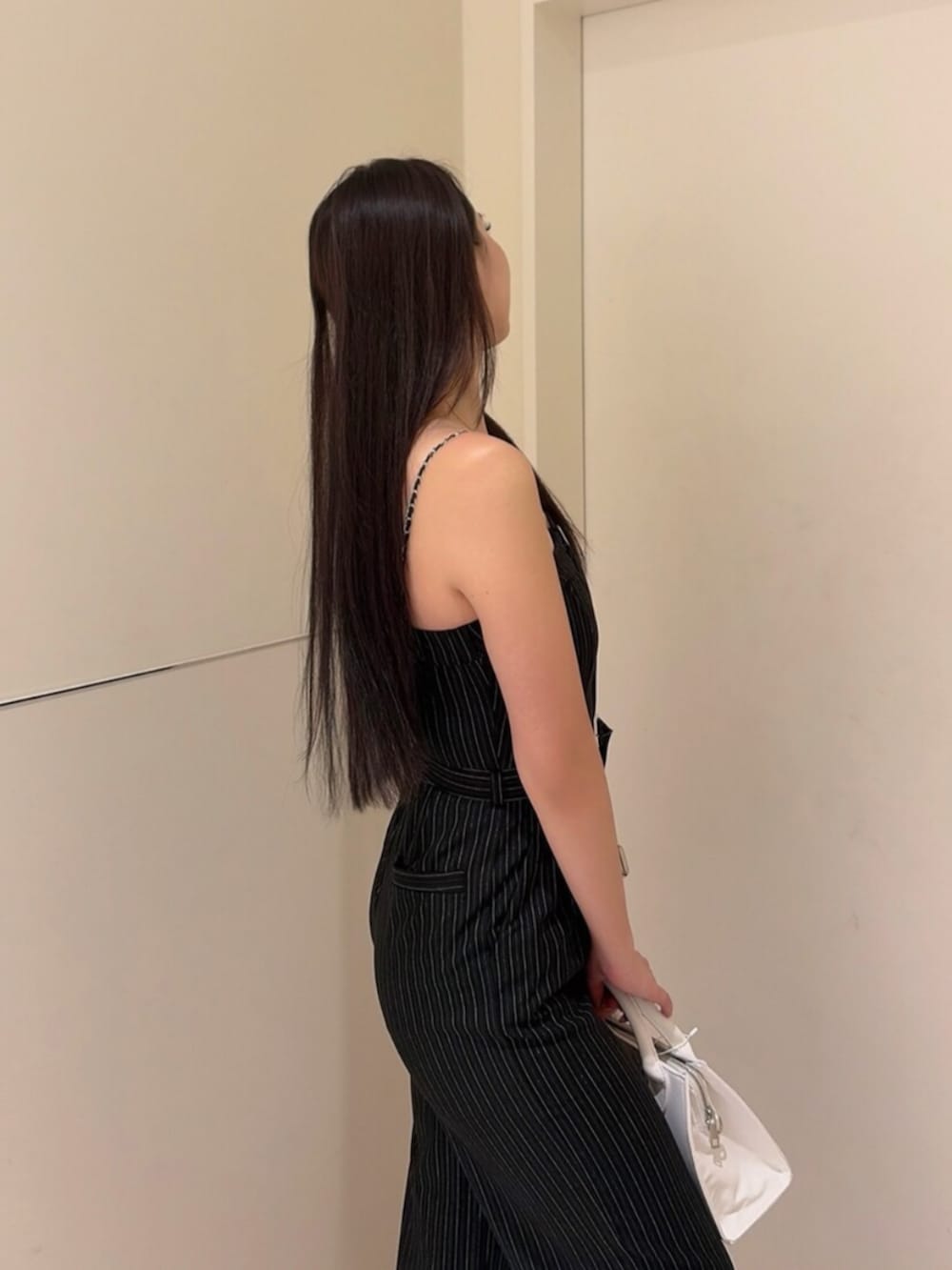 ブラック系のパンプス、ブラック系のつなぎ/オールインワン、ホワイト系のハンドバッグを着用したレディースの秋コーディネートの5枚目の写真