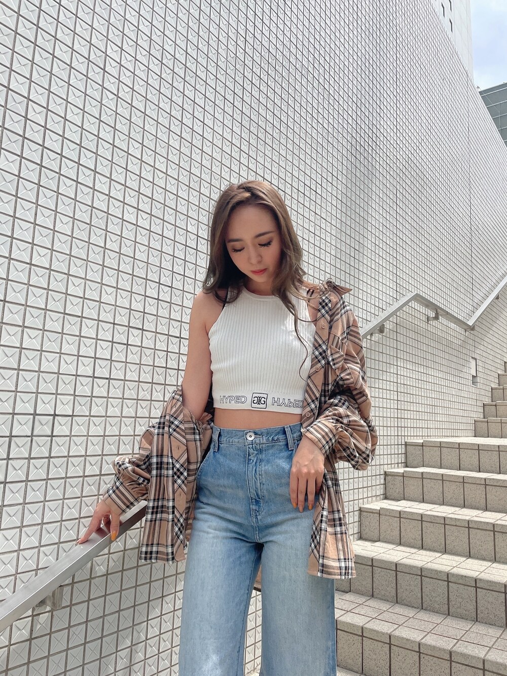 ベージュ系のシャツ/ブラウス、ホワイト系のタンクトップ、ブルー系のデニムパンツを着用したレディースの春コーディネートの4枚目の写真