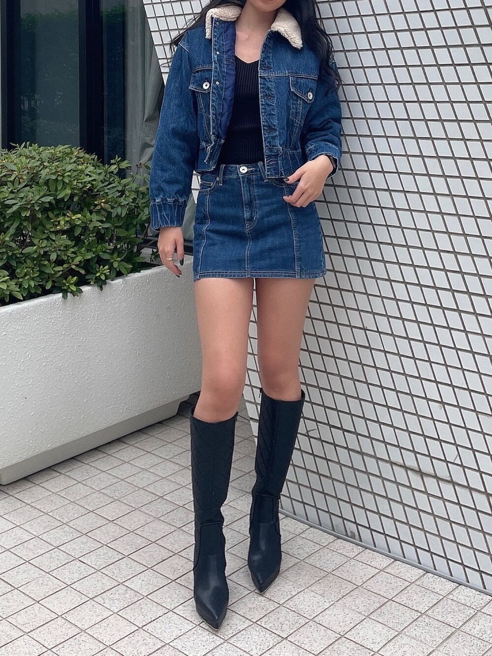 ブルー系のデニムジャケット、ブルー系のデニムスカート、ブラック系のニット/セーターを着用したレディースの秋コーディネートの4枚目の写真