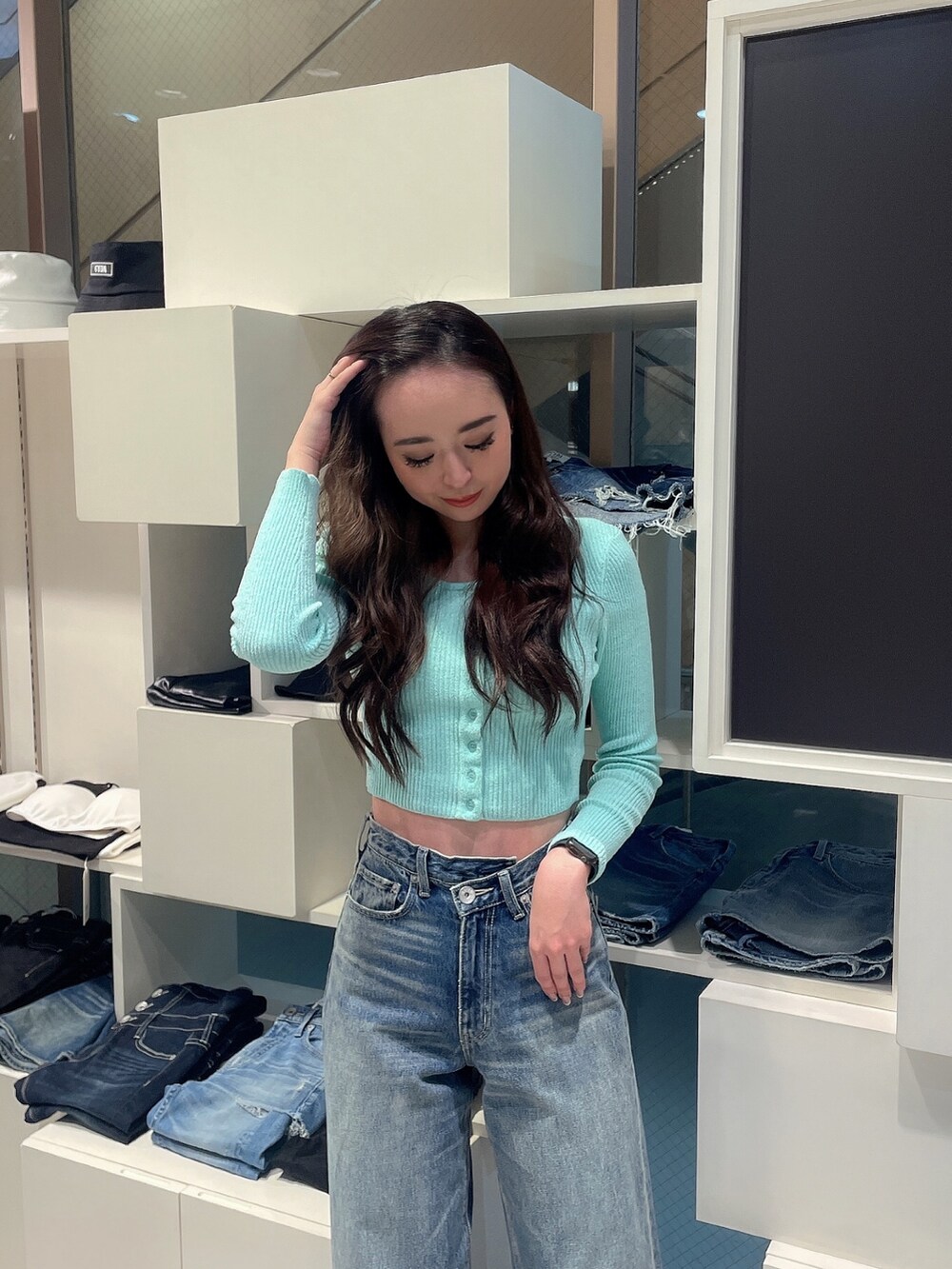 グリーン系のカーディガン/ボレロ、ブルー系のデニムパンツ、ブラック系のパンプスを着用したレディースの冬コーディネートの4枚目の写真