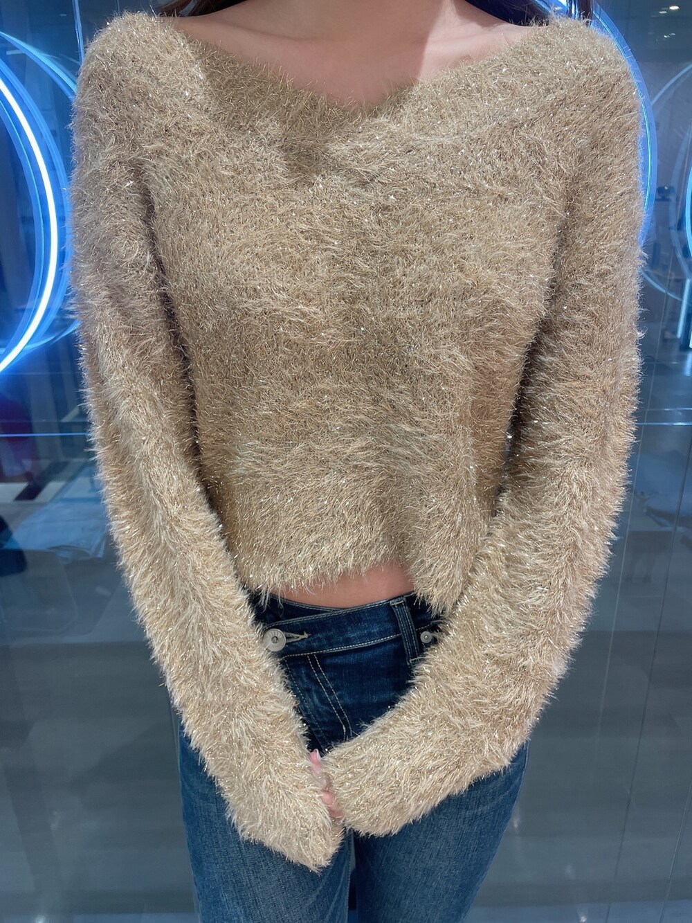 ベージュ系のニット/セーター、ブルー系のデニムパンツ、ブラック系のブーツを着用したレディースの冬コーディネートの6枚目の写真