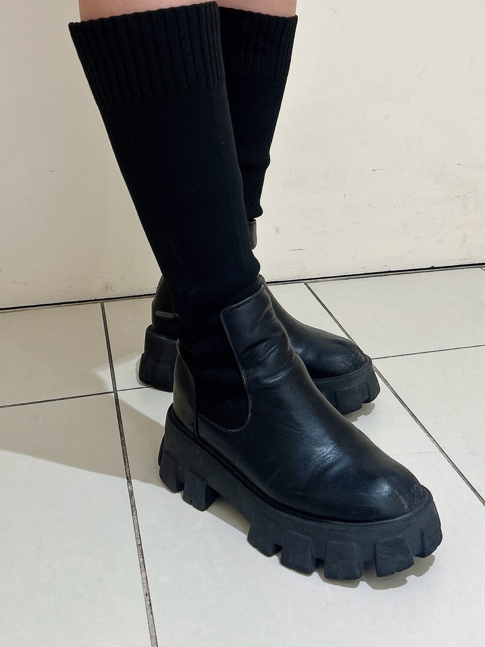 グリーン系のスウェット、ブラック系のスカート、ブラック系のブーツを着用したレディースの冬コーディネートの7枚目の写真