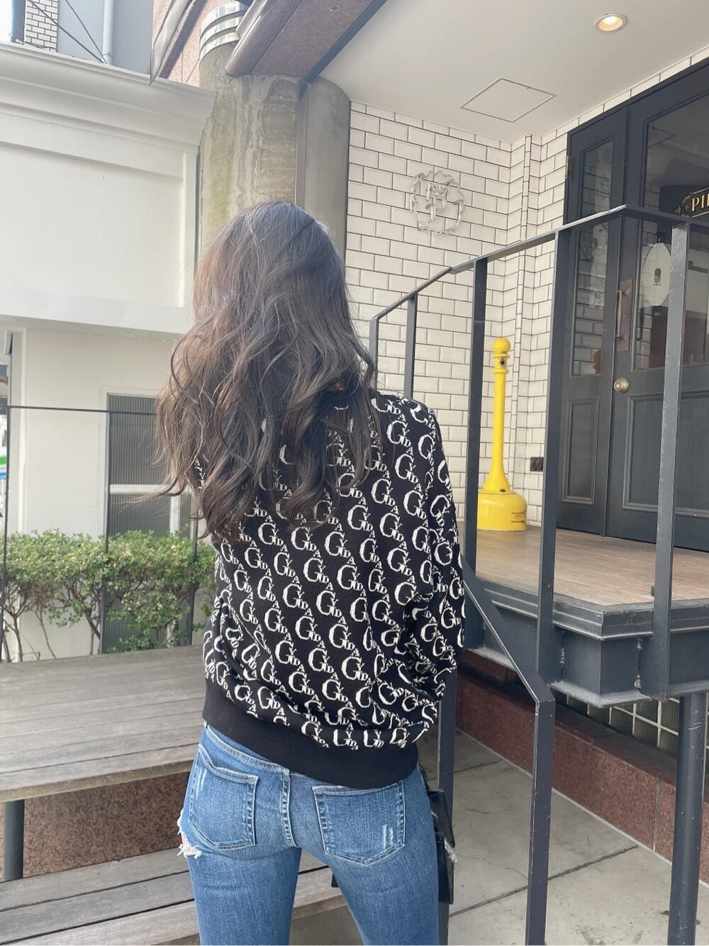 ブラック系のニット/セーター、ブラック系のパンプス、ブルー系のデニムパンツを着用したレディースの冬コーディネートの3枚目の写真