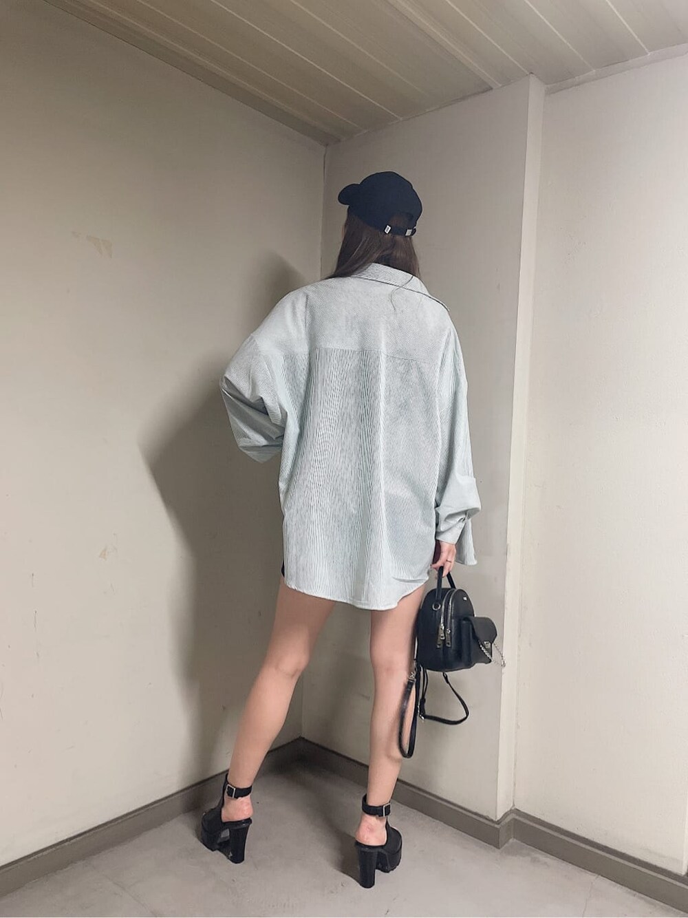 グリーン系のシャツ/ブラウス、ブラック系のバックパック/リュック、ブラック系のブーツを着用したレディースの春コーディネートの4枚目の写真