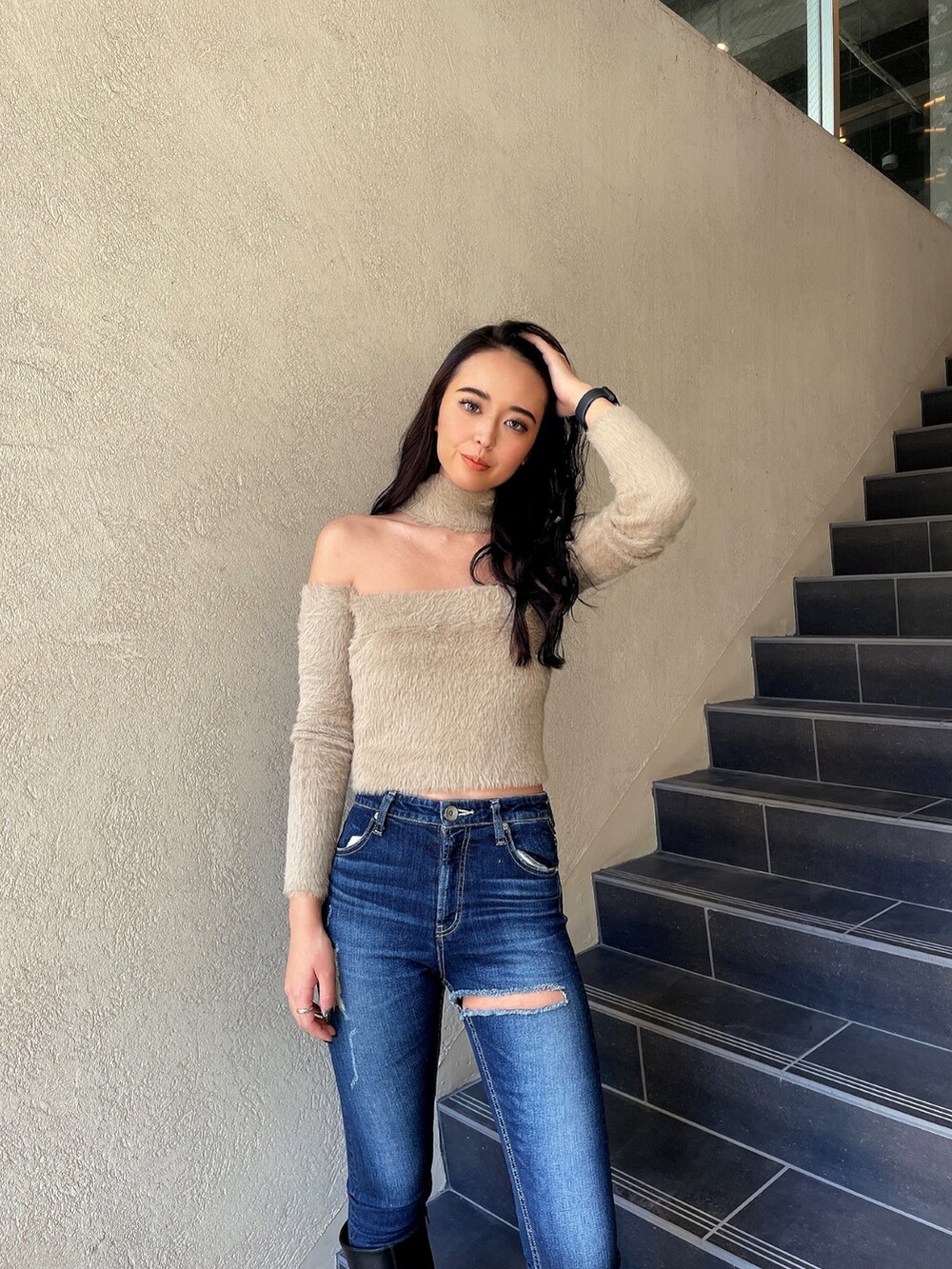 ベージュ系のニット/セーター、ブルー系のデニムパンツ、ブラック系のブーツを着用したレディースの秋コーディネートの2枚目の写真