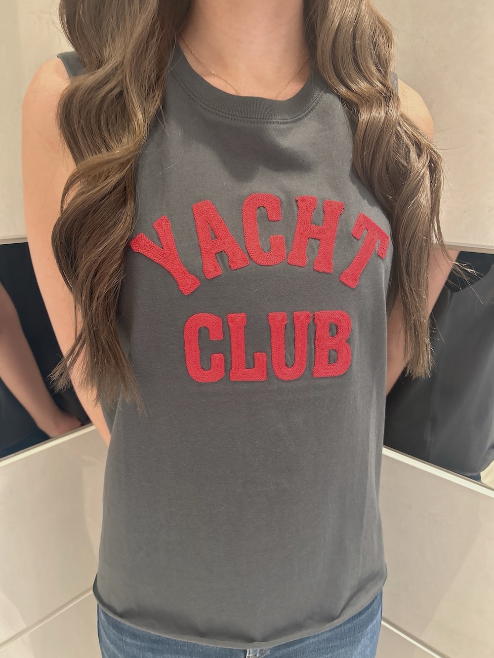 グレー系のタンクトップ、ブルー系のデニムパンツ、ベージュ系のサンダルを着用したレディースの夏コーディネートの7枚目の写真