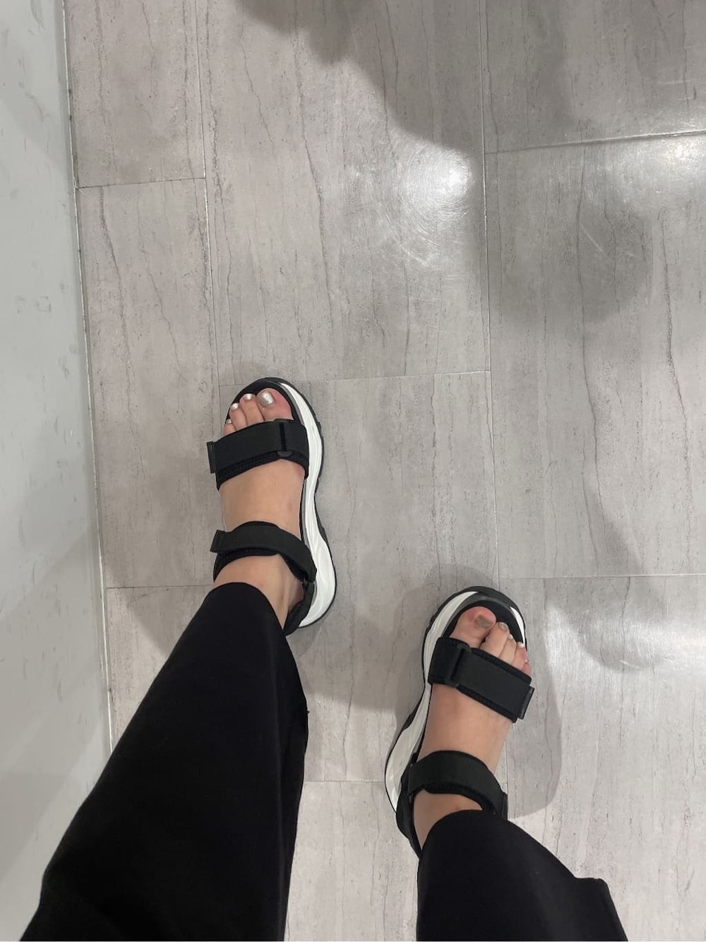 ブラック系のパーカー、グレー系のその他パンツ、ブラック系のキャミソールを着用したレディースの春コーディネートの7枚目の写真