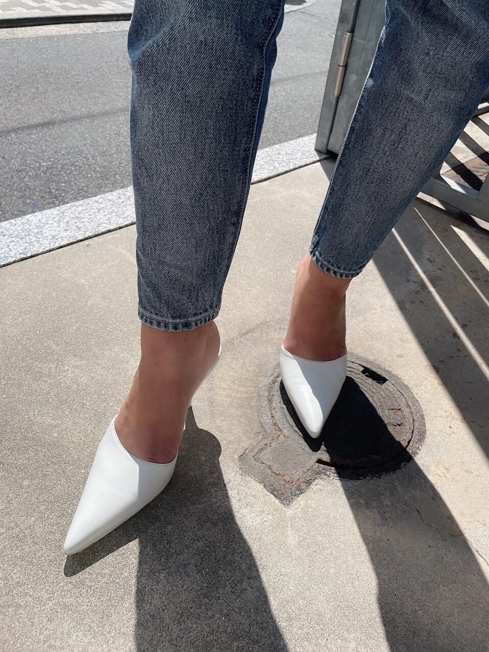 ブルー系のデニムパンツ、ブルー系のデニムジャケット、ホワイト系のキャミソールを着用したレディースの秋コーディネートの8枚目の写真