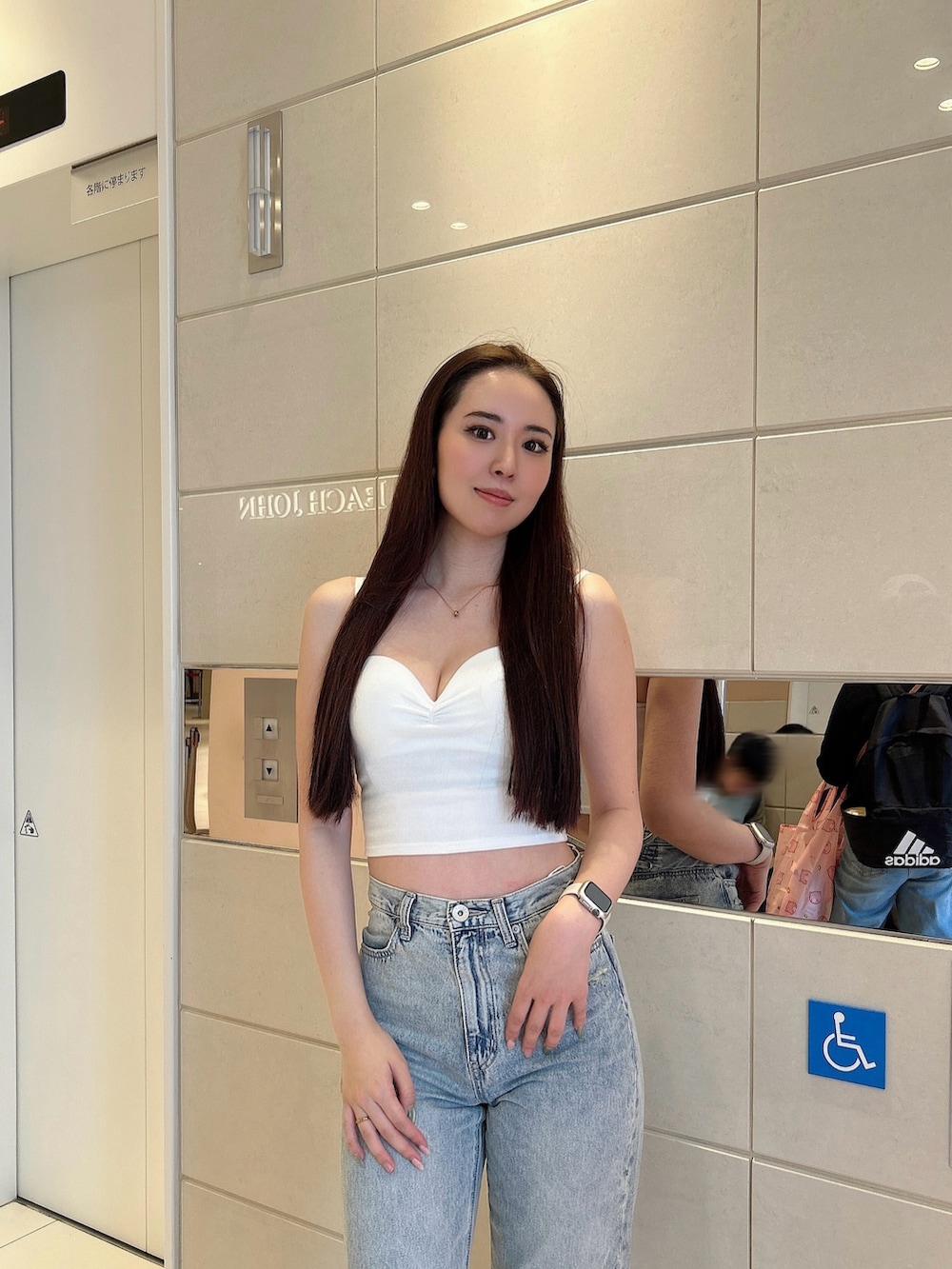 ホワイト系のキャミソール、ブルー系のデニムパンツ、ホワイト系のパンプスを着用したレディースの春コーディネートの4枚目の写真