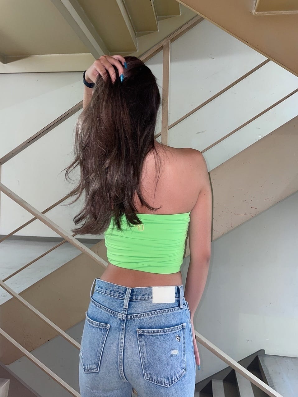 ホワイト系のサンダル、ブルー系のデニムパンツ、グリーン系のチューブトップを着用したレディースの夏コーディネートの7枚目の写真