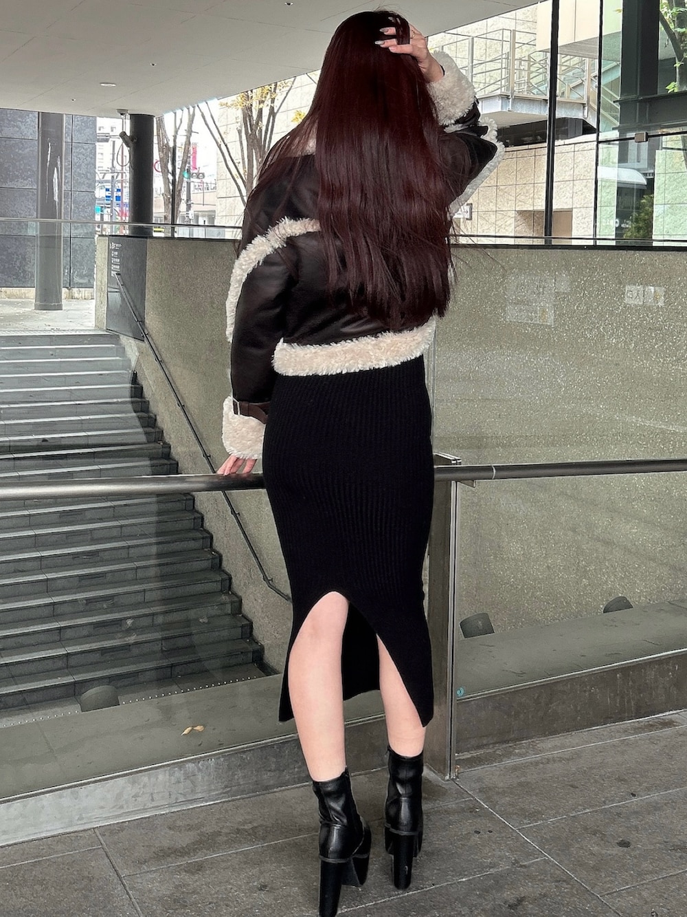 ブラウン系のムートンコート、ブラック系のブーツを着用したレディースの秋コーディネートの3枚目の写真