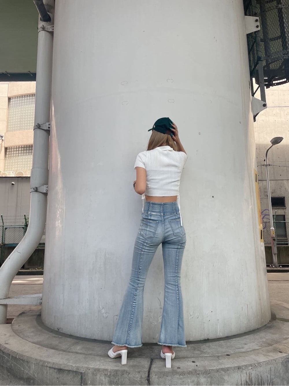 ホワイト系のニット/セーター、ホワイト系のサンダル、ブルー系のデニムパンツを着用したレディースの夏コーディネートの4枚目の写真