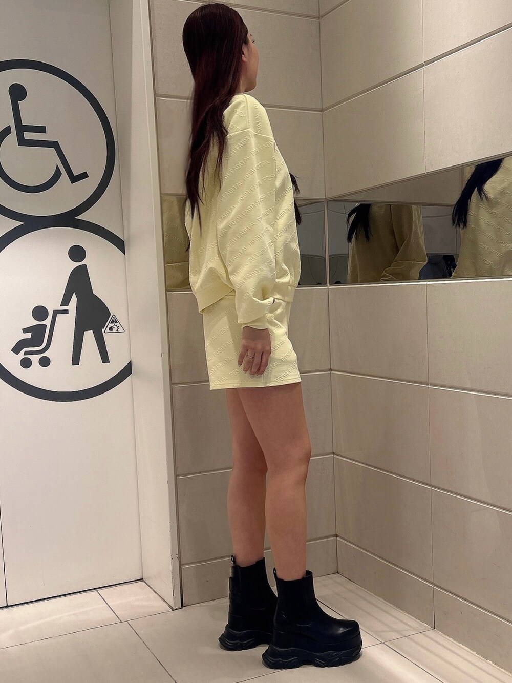 イエロー系のスウェット、イエロー系のその他パンツ、ブラック系のブーツを着用したレディースの冬コーディネートの2枚目の写真