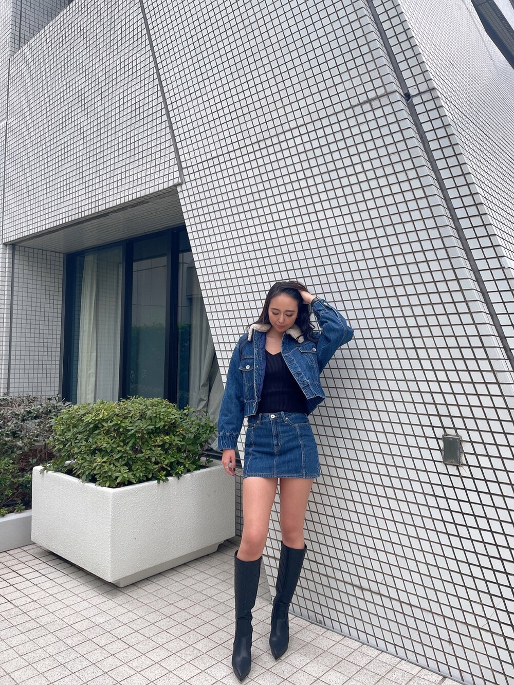 ブルー系のデニムジャケット、ブルー系のデニムスカート、ブラック系のニット/セーターを着用したレディースの秋コーディネートの2枚目の写真