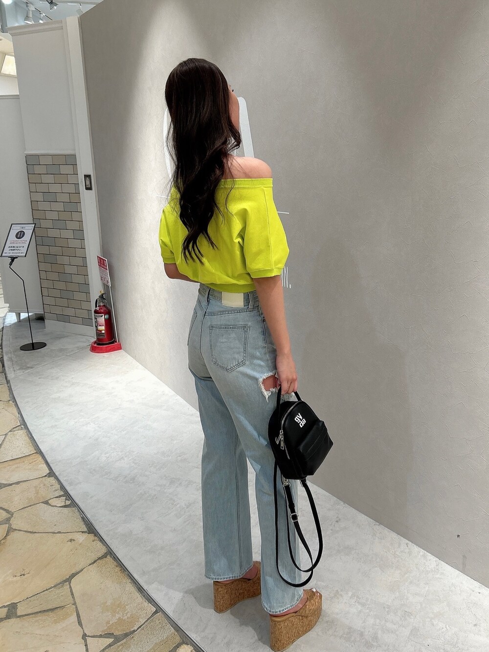 イエロー系のTシャツ/カットソー、ブルー系のデニムパンツ、ベージュ系のサンダルを着用したレディースの春コーディネートの2枚目の写真