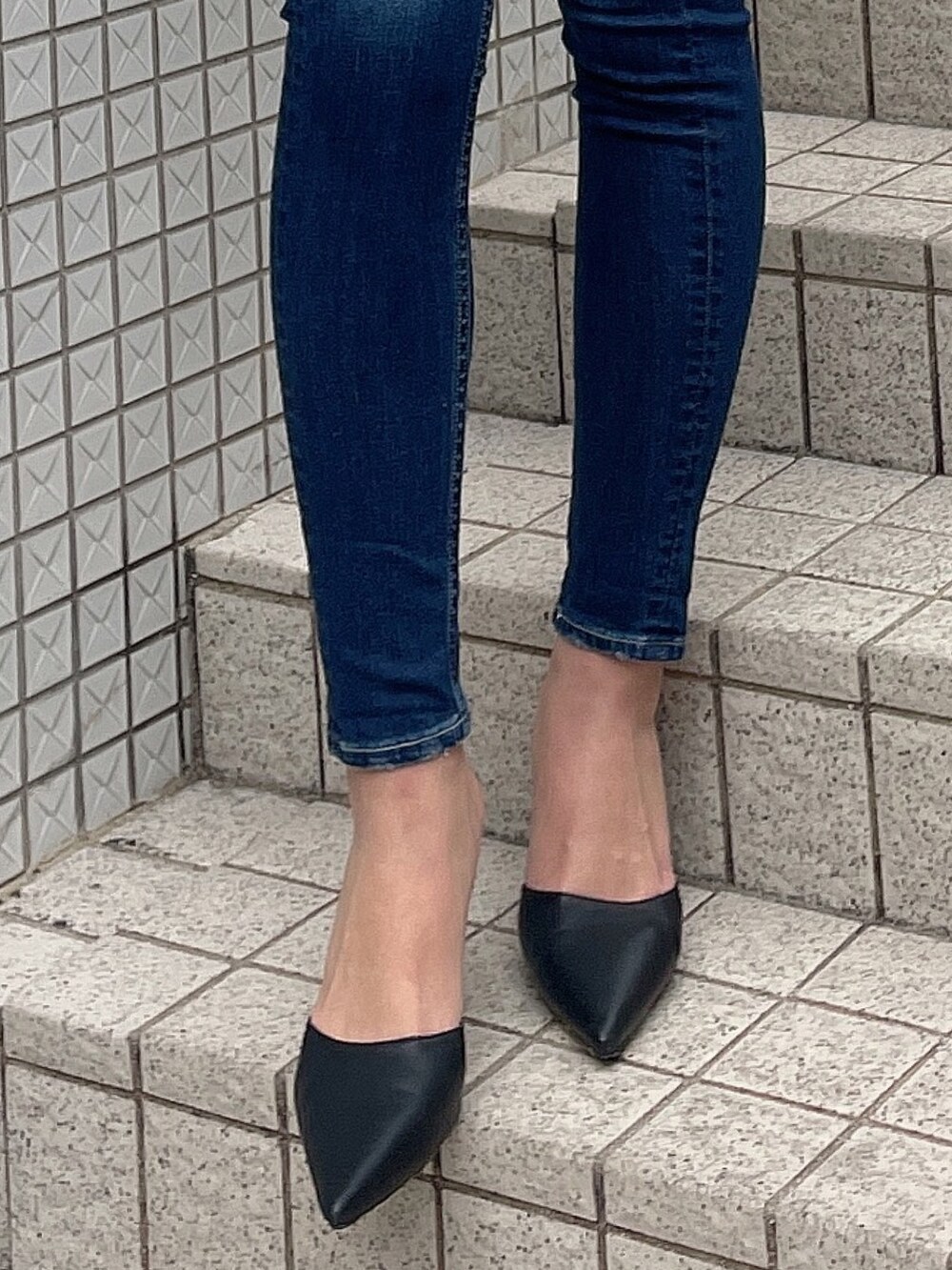 ブラック系のニット/セーター、ブルー系のデニムパンツ、ブラック系のパンプスを着用したレディースの冬コーディネートの7枚目の写真