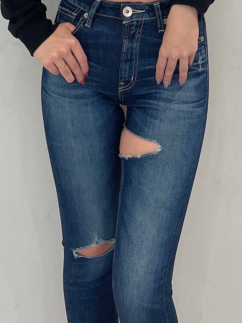 ブラック系のパーカー、ホワイト系のキャミソール、ブルー系のデニムパンツを着用したレディースの冬コーディネートの6枚目の写真