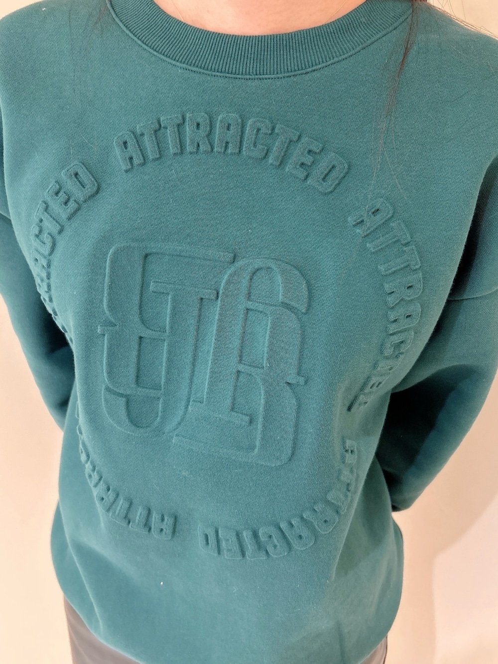 グリーン系のスウェット、ブラック系のスカート、ブラック系のブーツを着用したレディースの冬コーディネートの6枚目の写真