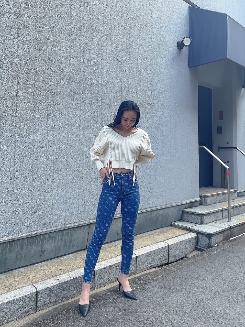 ホワイト系のパンプス、ブルー系のデニムパンツ、ホワイト系のニット/セーターを着用したレディースの春コーディネートの2枚目の写真