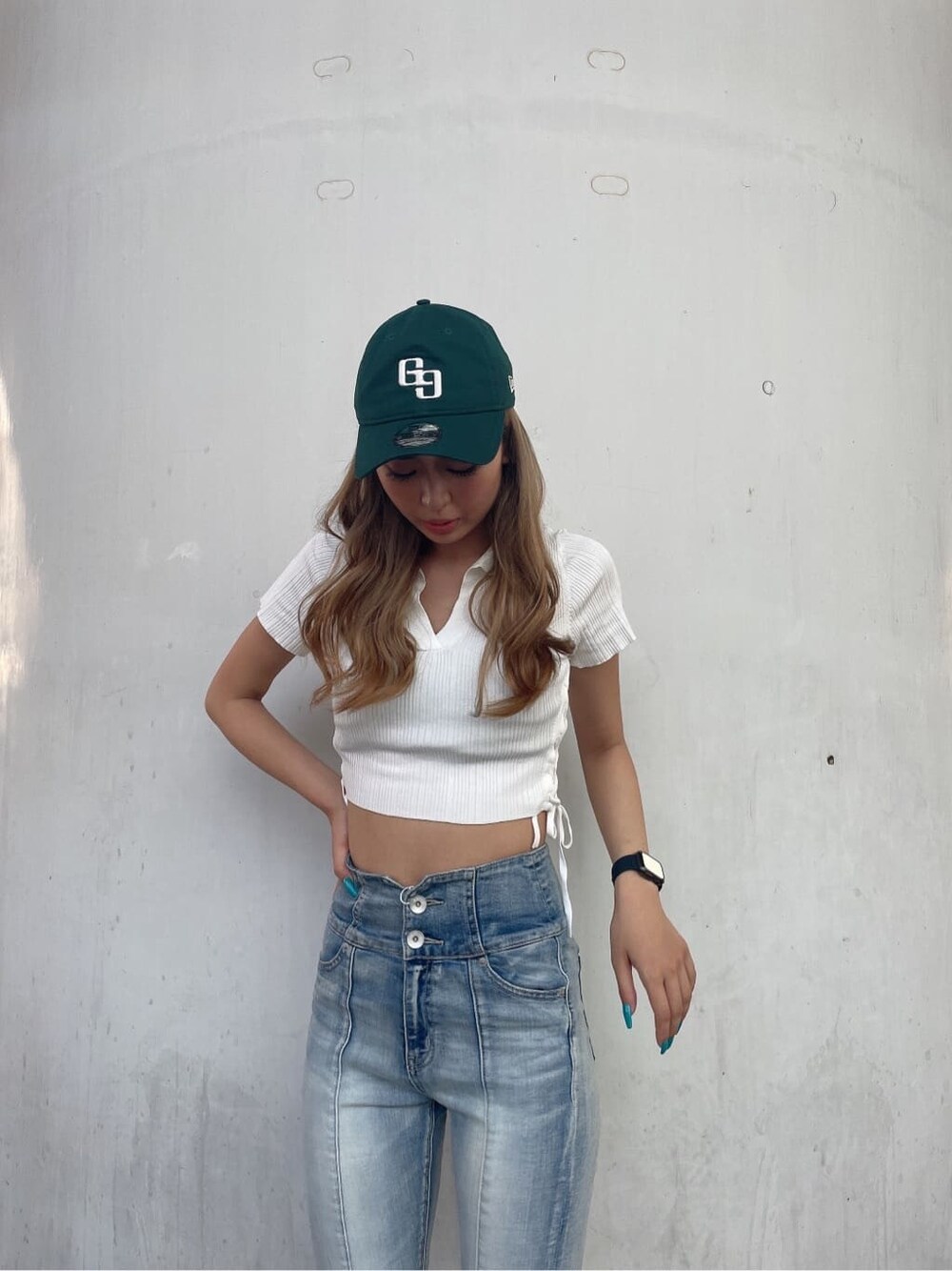 ホワイト系のニット/セーター、ホワイト系のサンダル、ブルー系のデニムパンツを着用したレディースの夏コーディネートの2枚目の写真