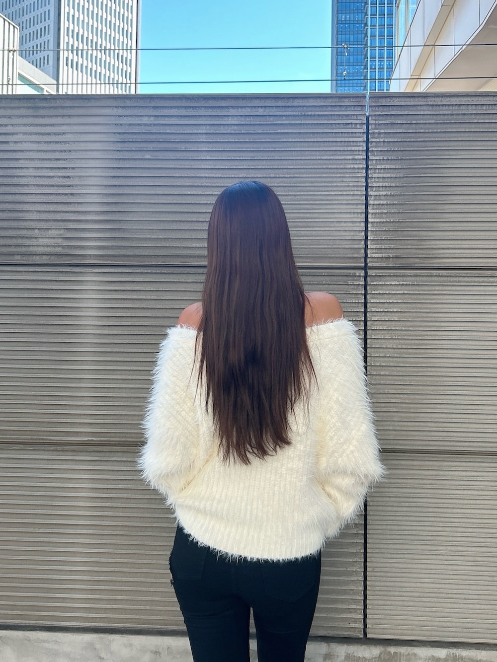 ホワイト系のニット/セーター、ブラック系のデニムパンツ、ブラック系のブーツを着用したレディースの秋コーディネートの7枚目の写真