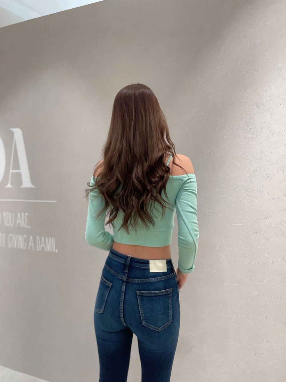 グリーン系のTシャツ/カットソー、ブルー系のデニムパンツ、ブラック系のパンプスを着用したレディースの春コーディネートの5枚目の写真