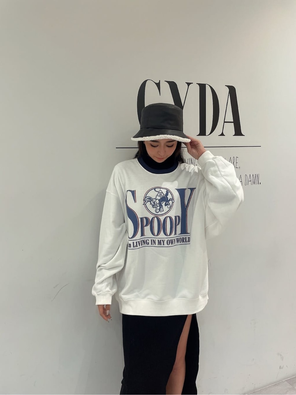 ホワイト系のスウェット、ブラック系のパンプス、ブラック系のワンピースを着用したレディースの秋コーディネートの2枚目の写真