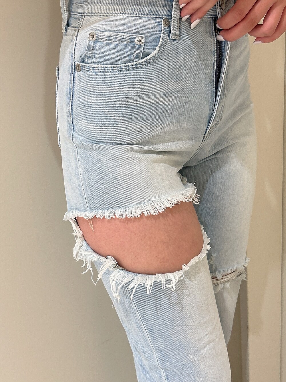 ホワイト系のパーカー、ブルー系のデニムパンツ、ホワイト系のチューブトップを着用したレディースの春コーディネートの8枚目の写真