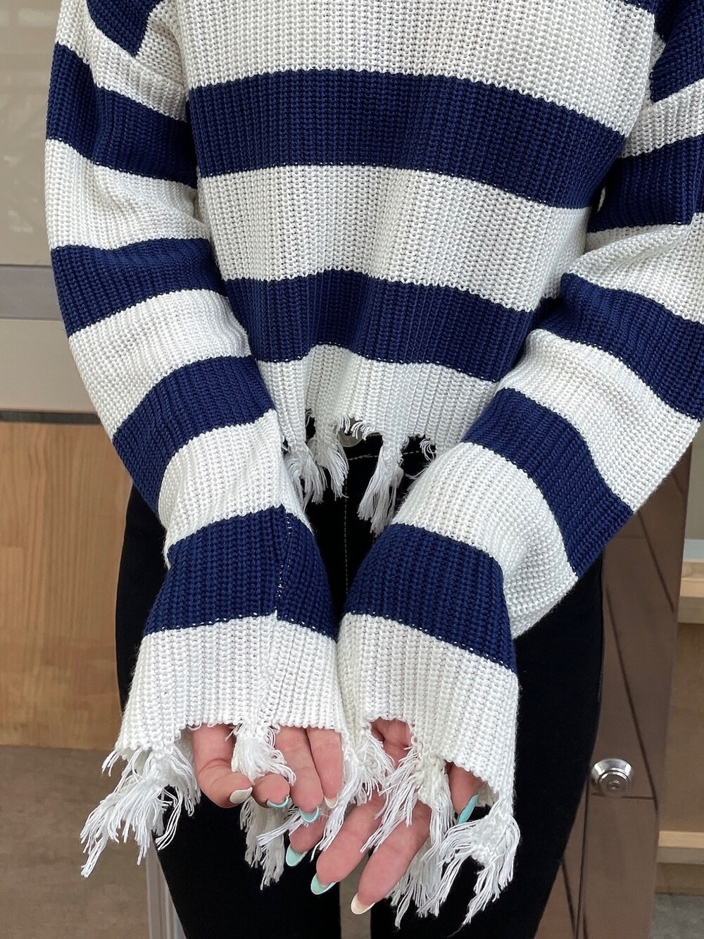 ブルー系のニット/セーター、ブルー系のデニムパンツ、ブラック系のパンプスを着用したレディースの夏コーディネートの6枚目の写真