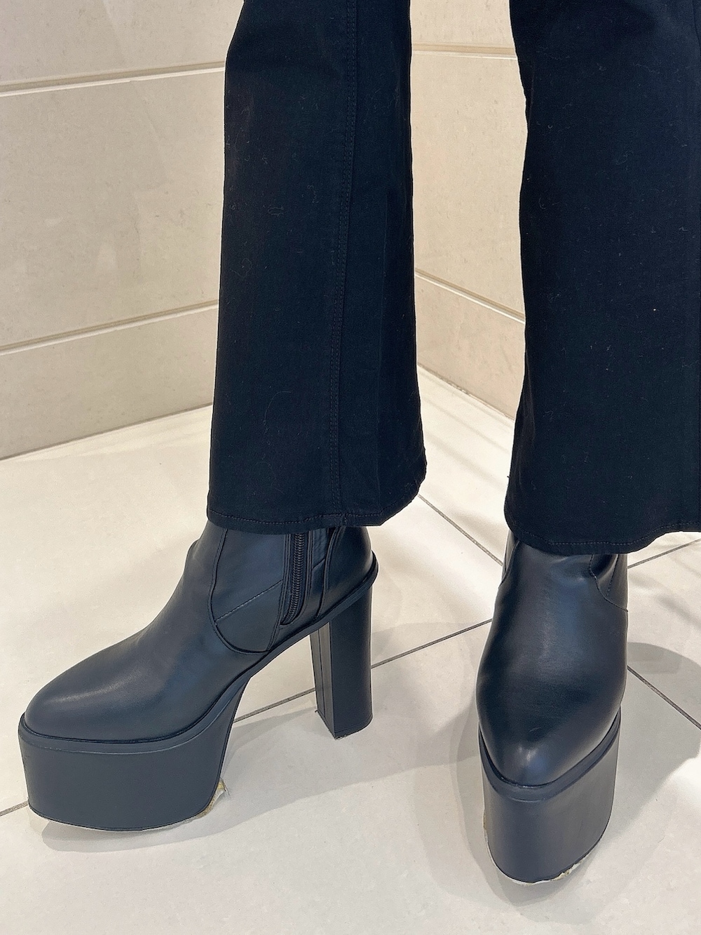 ホワイト系のニット/セーター、ブラック系のデニムパンツ、ブラック系のブーツを着用したレディースの冬コーディネートの7枚目の写真