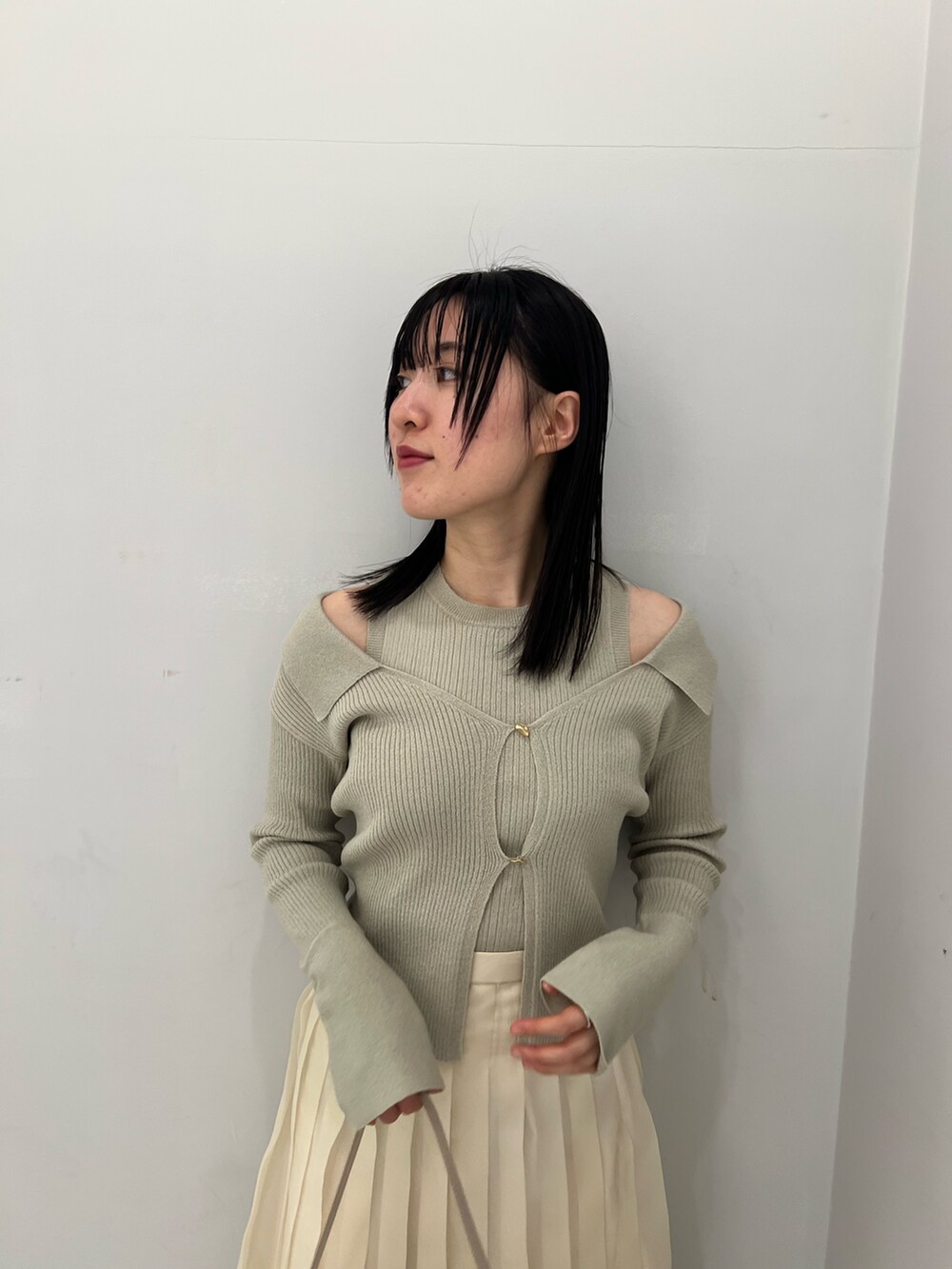 ホワイト系のスカート、グリーン系のアンサンブルを着用したレディースの冬コーディネートの2枚目の写真