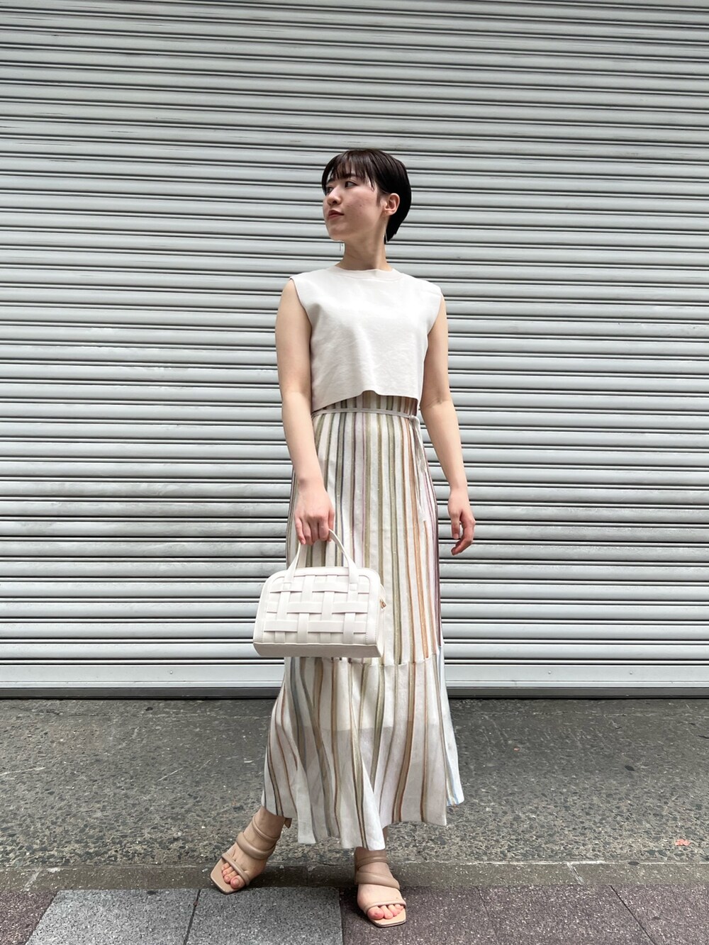 ホワイト系のショルダーバッグ、ベージュ系のサンダル、ホワイト系のワンピースを着用したレディースの春コーディネートの4枚目の写真